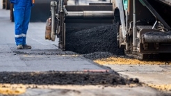 Close view on the workers and the asphalting machines