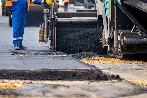 Close view on the workers and the asphalting machines