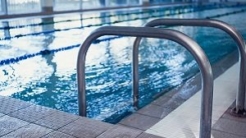 Large blue pool with a ladder in the forefront