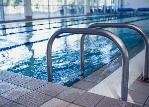 Large blue pool with a ladder in the forefront