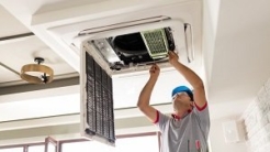 Contractor working on an HVAC system in the ceiling