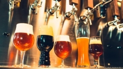 The beer taps in a pub. nobody. Selective focus. Alcohol concept. Vintage style. Beer craft. Bar table. Steel taps. Shiny taps. Glass of beer