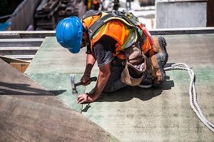 Roofer installing shingles on roof