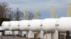 Several large white storage tanks lined up