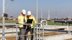 Two environmental contractors looking at a laptop