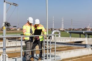 Two environmental contractors looking at a laptop