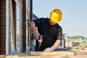 Man in hardhat drilling wood