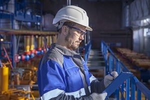 Man in hard hat and blue coat with clipboard