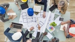 Construction meeting with several people sitting around a table