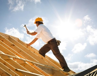 Construction worker hammering on a roof