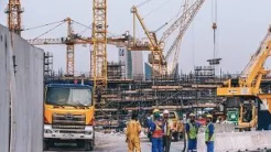 Construction site with truck, workers, cranes