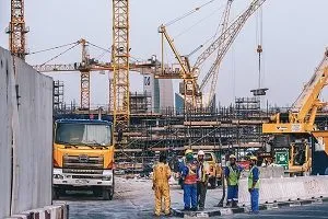 Construction site with truck, workers, cranes