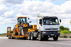 Semi-trailer truck Renault Premium drives at the interurban freeway.